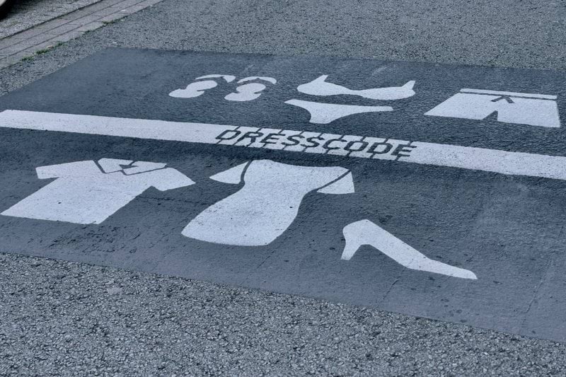 Dresscode sign on the streets. Depending on what side of the line you are, you should me dressed less naked.