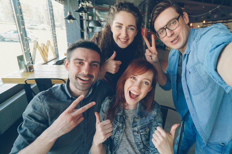 Friends happily take a selfie together inside