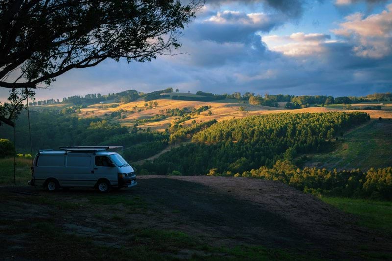 a van parked on top of a dirt road