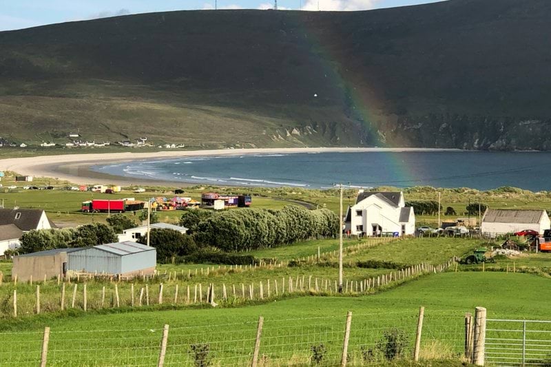 a rainbow in the sky over a green field