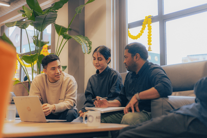 3 people sat around a table discussing something