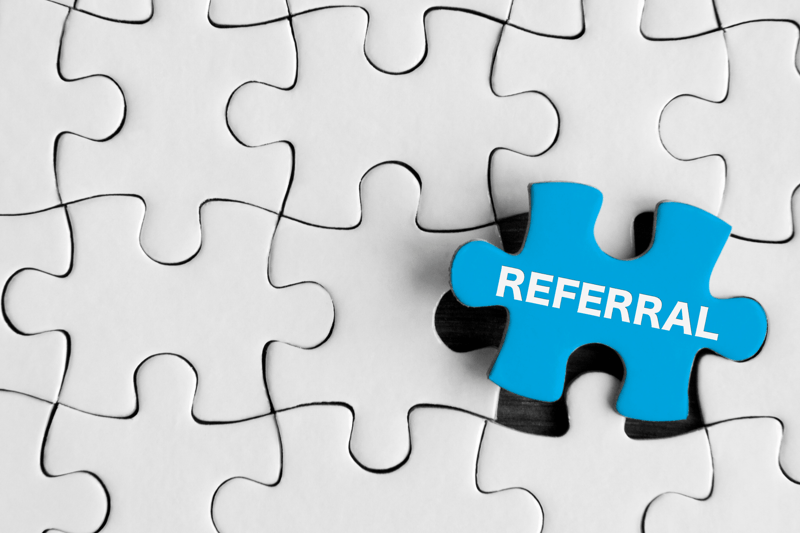 Photo of white jigsaw puzzle with once piece a light blue in colour with the writing 'referral'.
