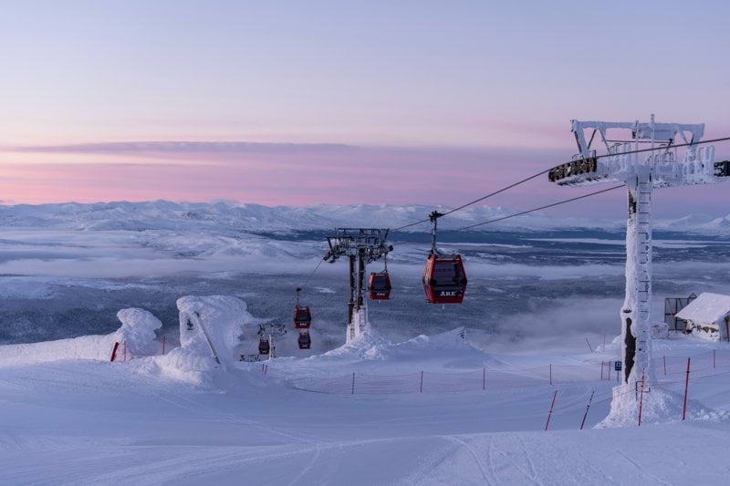 a ski lift going over a snow covered mountain