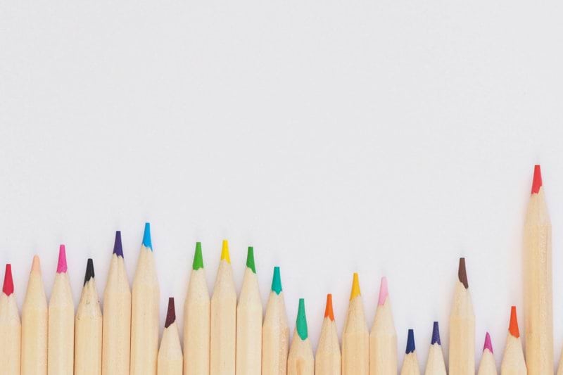 colored pencil lined up on top of white surface