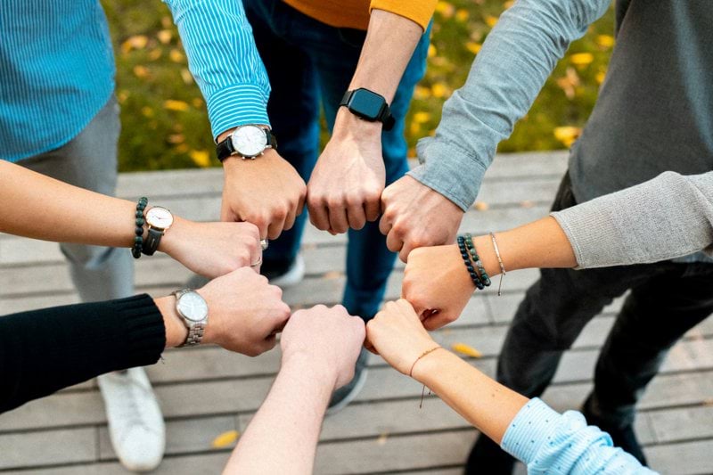 A group of people putting their hands together