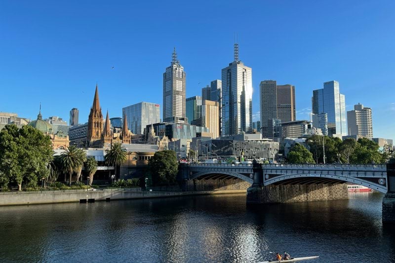 man riding on boat on river near city buildings during daytime