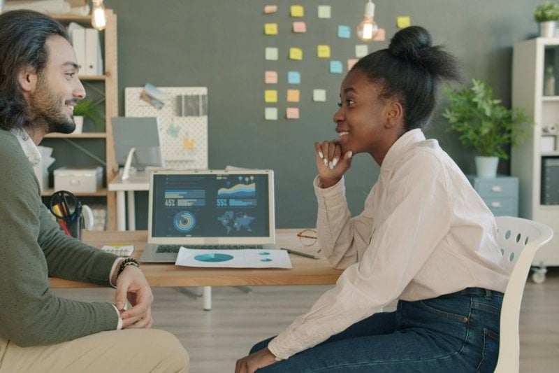 Two colleagues discussing work at a desk