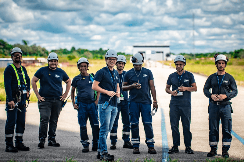 Photo de groupe de huit collaborateurs du Groupe ADF, posant en équipements de sécurité sur un site industriel extérieur