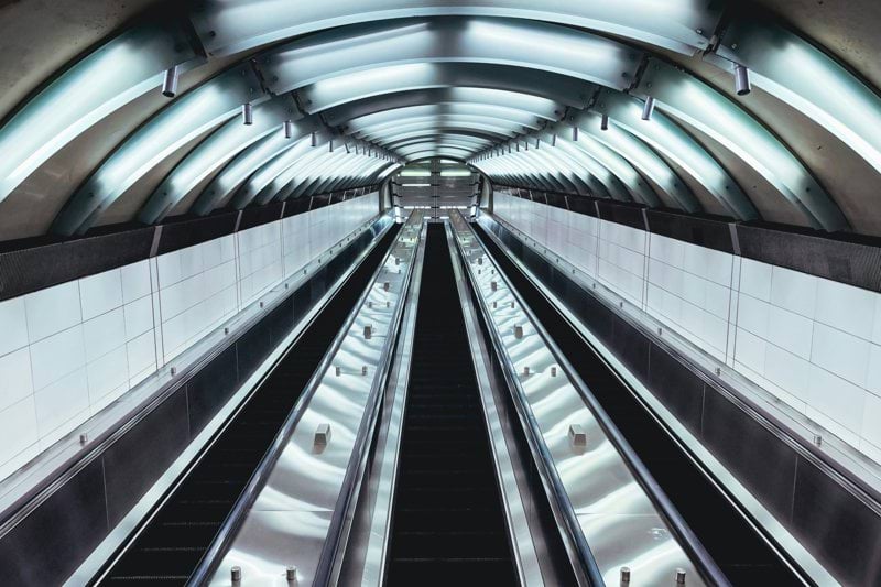 an escalator in a subway station with lights on