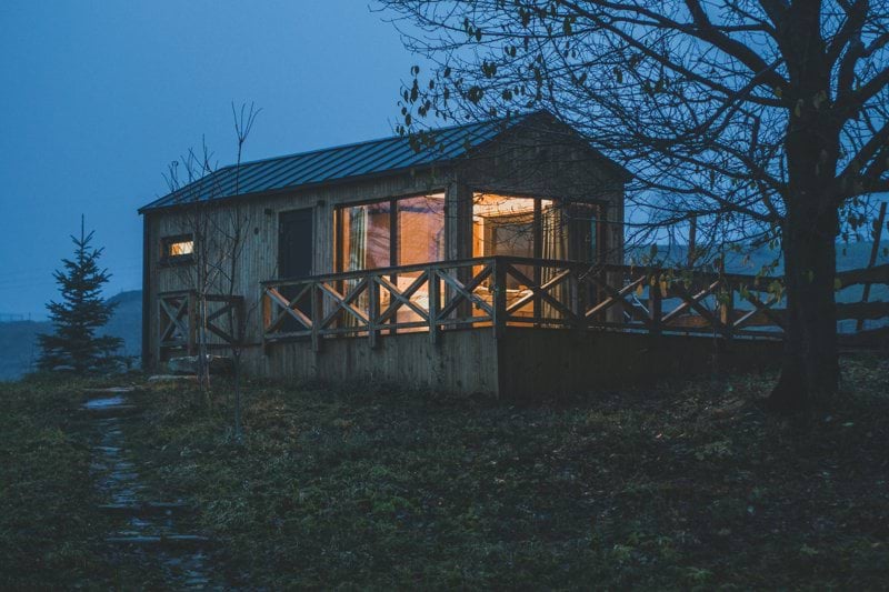 a small cabin sits on a hill at night
