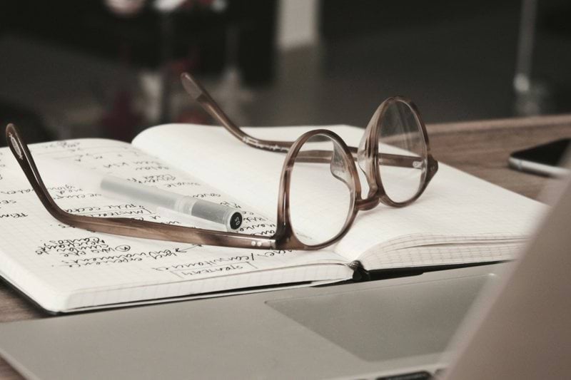 eyeglasses with gray frames on the top of notebook