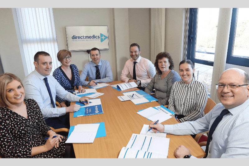 Direct Medics Staff Members sitting at table