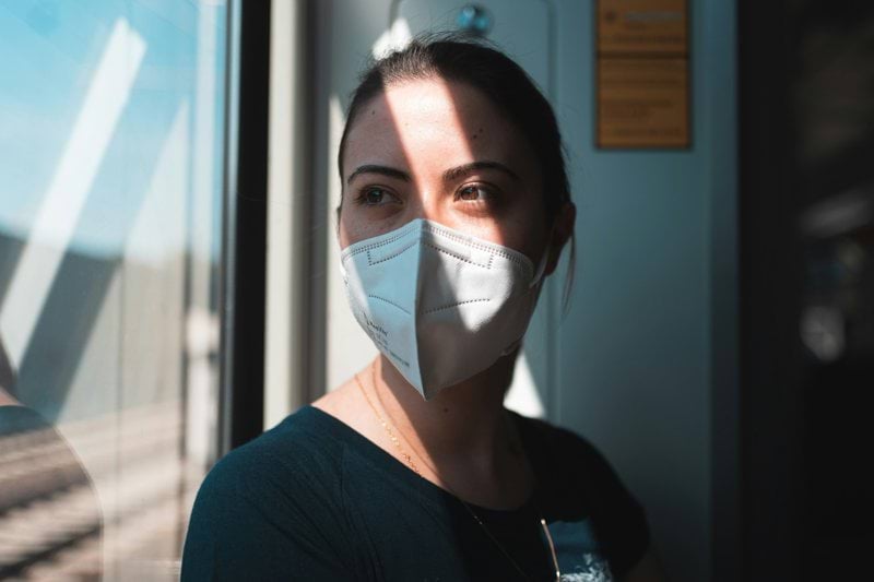 woman in black v neck shirt with white face mask