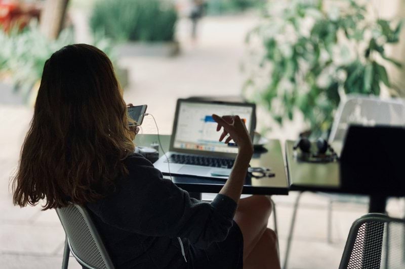 woman sitting on chair in front of table with laptop