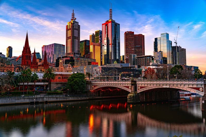 Melbourne's skyline reflecting in the water at sunset.
