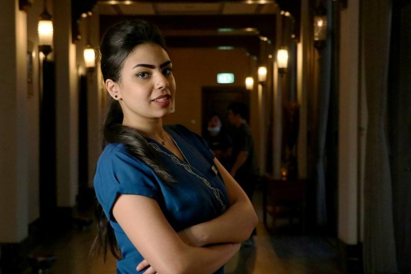 woman in blue shirt standing on hallway