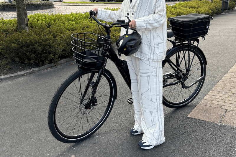 bild på en tjej som står vid sin cykel