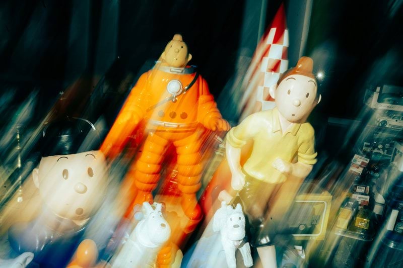Blurry figures of tintin and captain haddock with rocket.