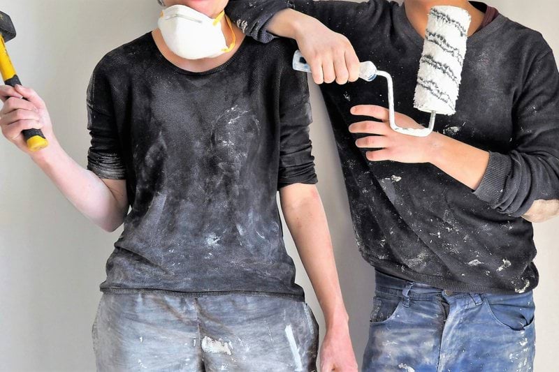 man and woman holding sledgehammer and paint roller