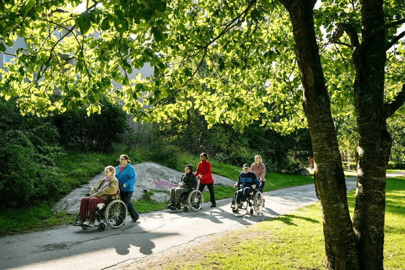 Kunder och medarbetare promenerar i en park