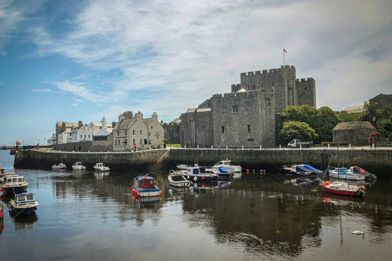 white and red boat on water near gray concrete building during daytime