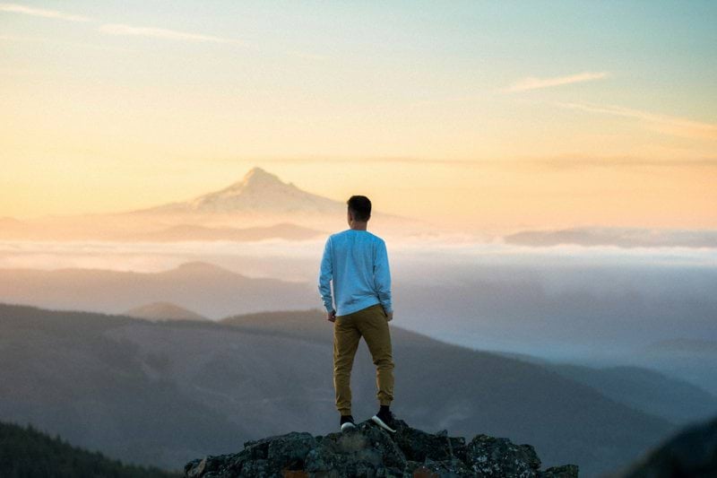 man standing on top of mountain