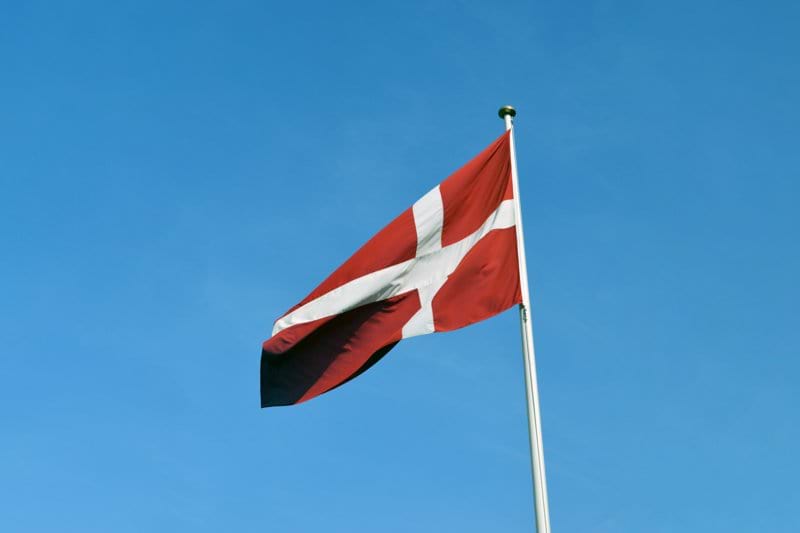 a red and white flag on a flagpole