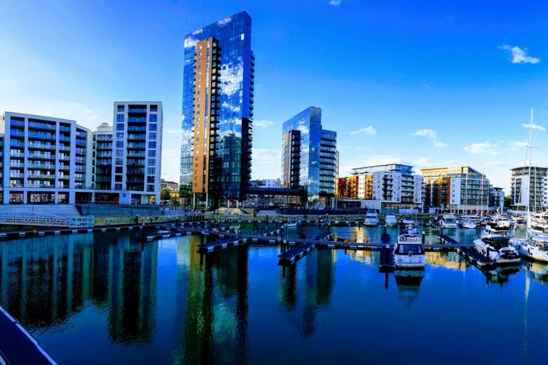 a marina filled with lots of boats next to tall buildings