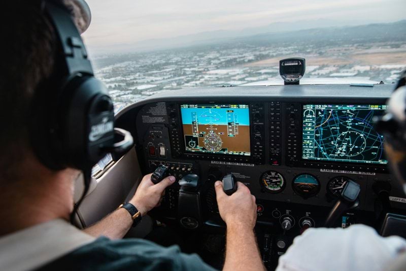man flying aircraft under cloudy sky