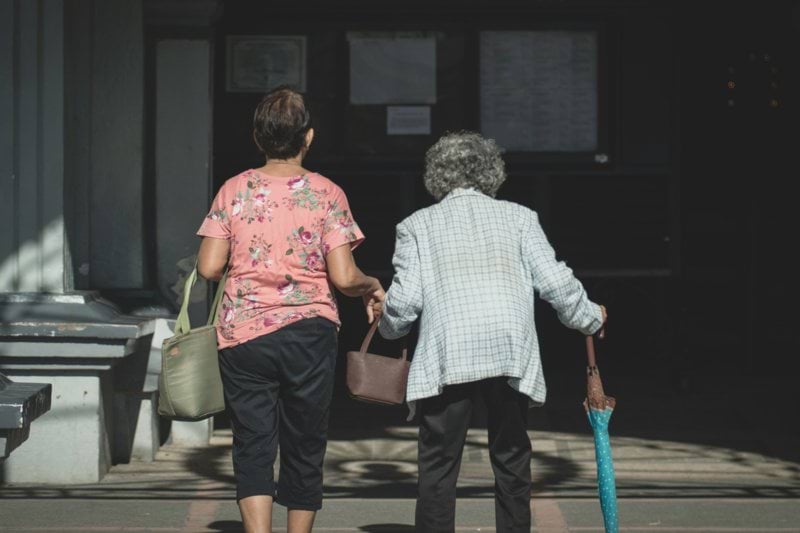 man in white and blue checked dress shirt standing beside woman in pink shirt