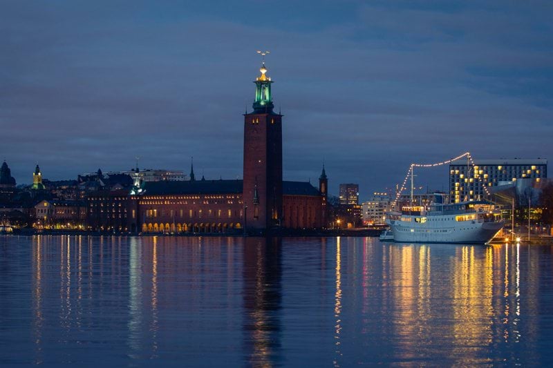 a large building with a clock tower next to a body of water