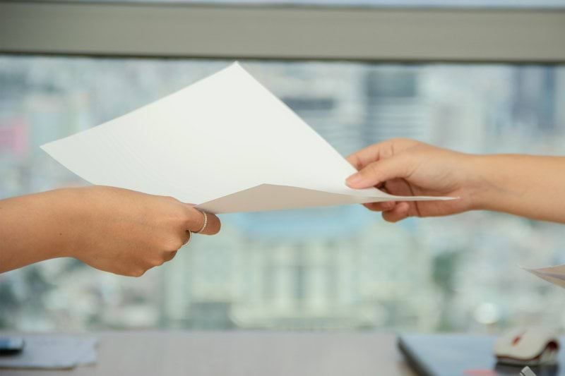 person handing over paper