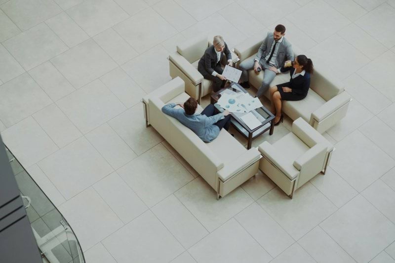 Business people meeting on sofas in a modern lobby.