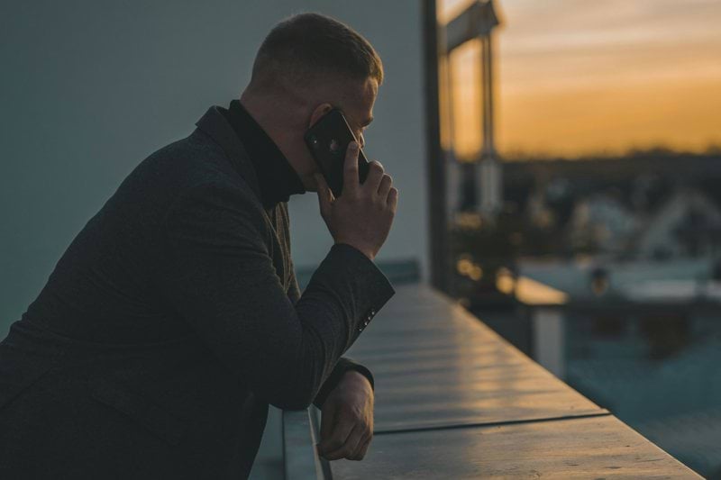 man in black long sleeve shirt sitting by the table