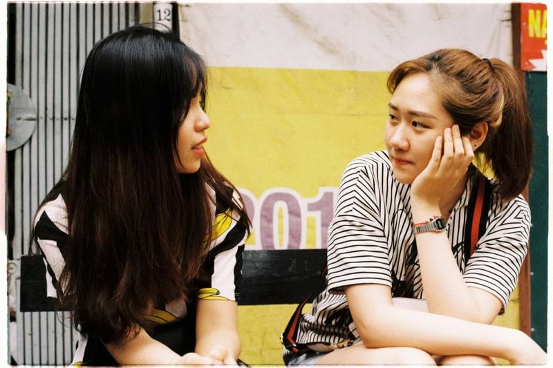 woman in white-and-black striped tops looking each other