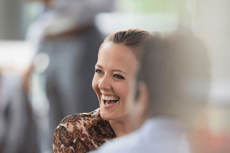 Lachende vrouw die in gesprek is