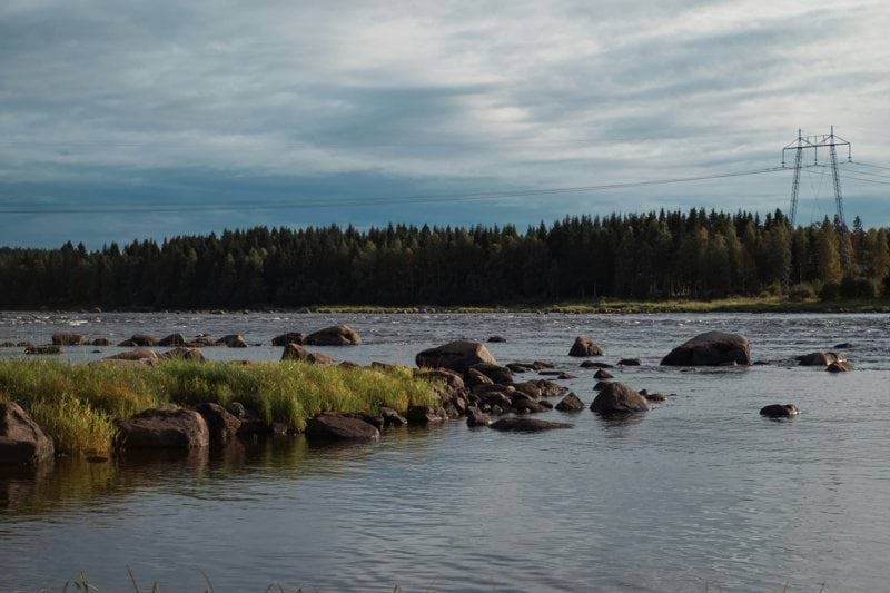 A body of water surrounded by rocks and grass
