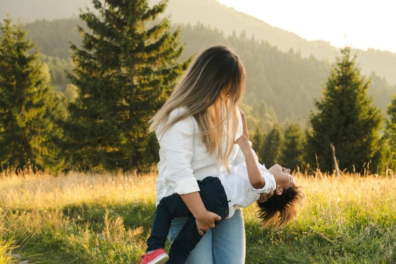 A woman holding a child in a field