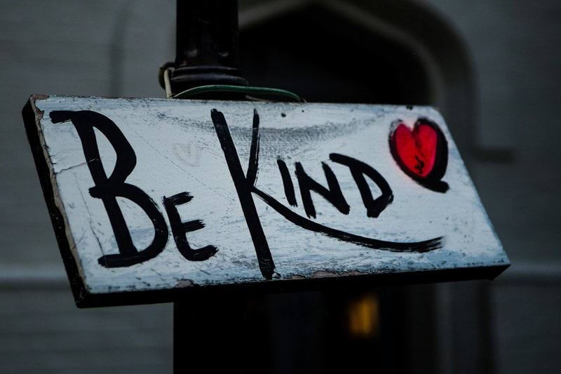 a sign that says be kind on it