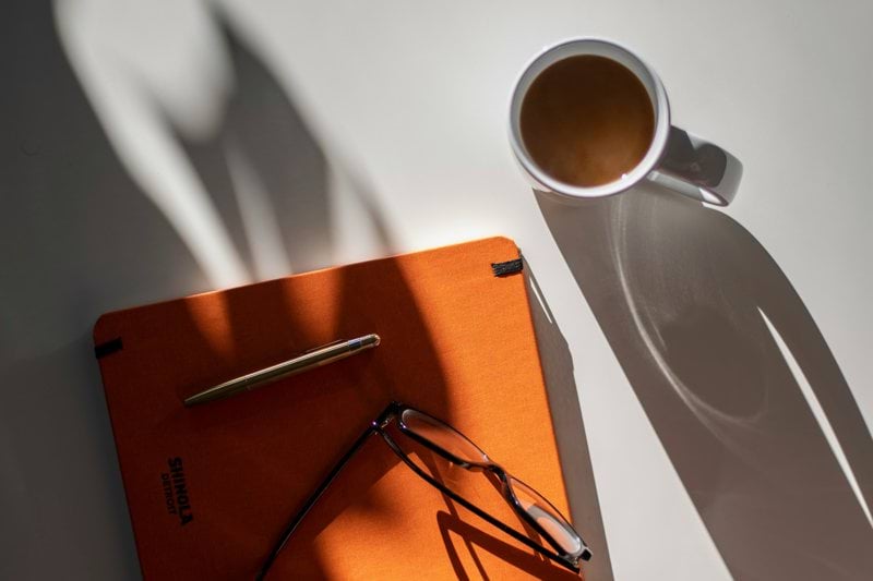 black framed eyeglasses on orange book