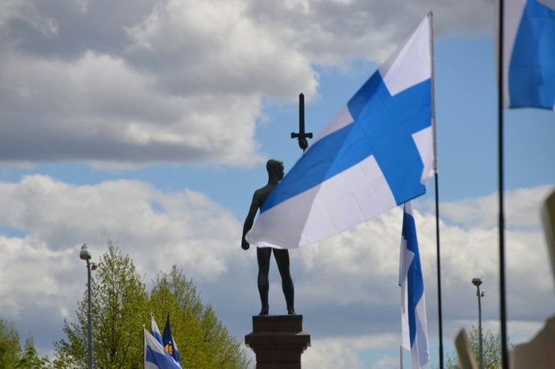 a statue of a person holding a cross and a flag