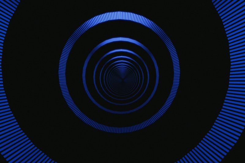 Abstract blue concentric circles on black background