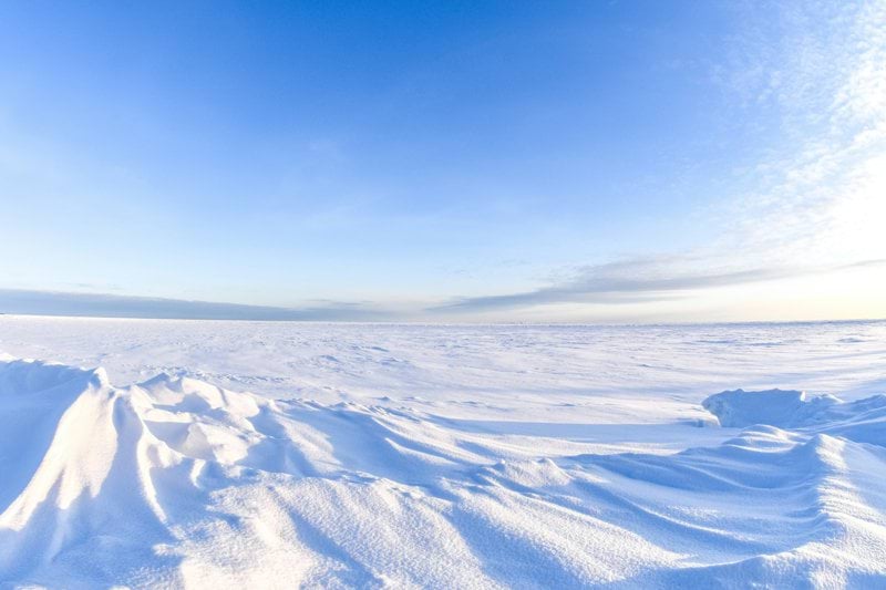 a snow covered landscape with a bright blue sky