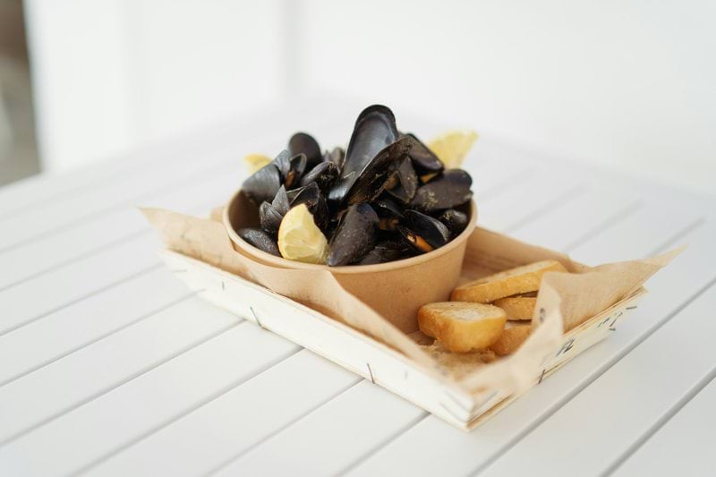 A bowl of mussels and fries on a table