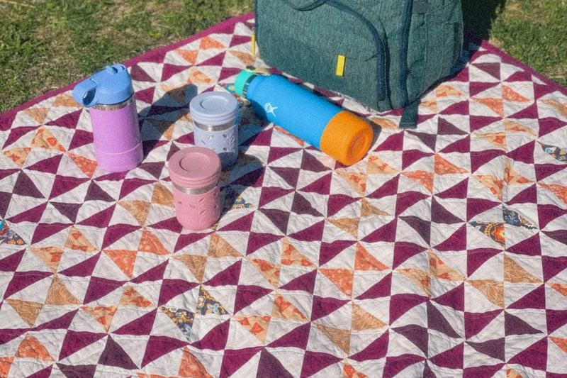 Picnic with a colorful blanket and a backpack.