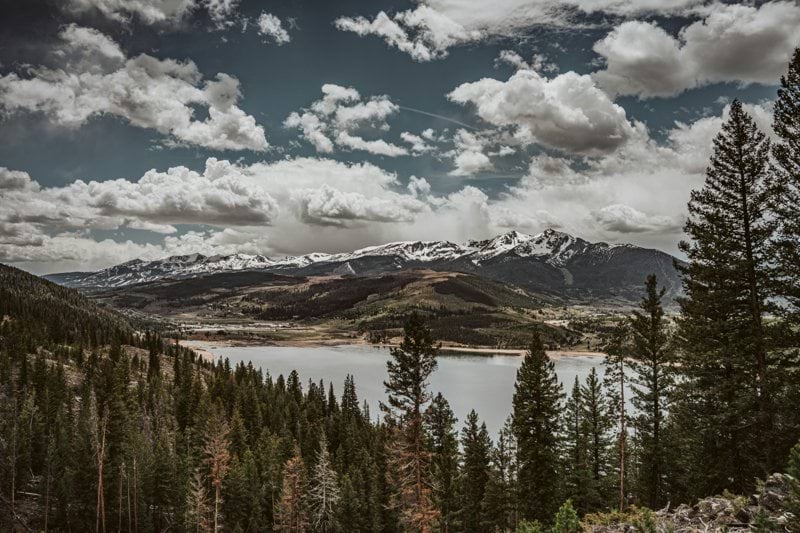 a scenic view of a mountain lake surrounded by pine trees