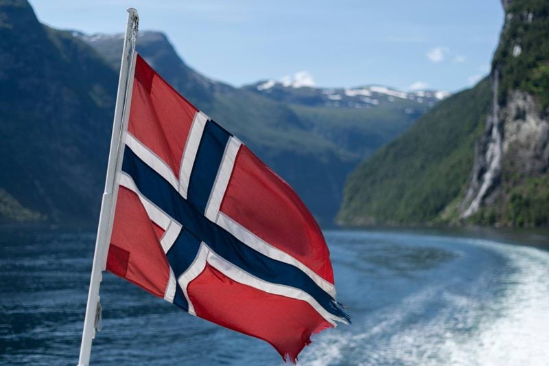 A flag flying from a boat in a body of water