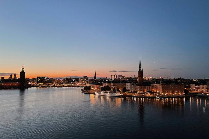 body of water near city buildings during night time
