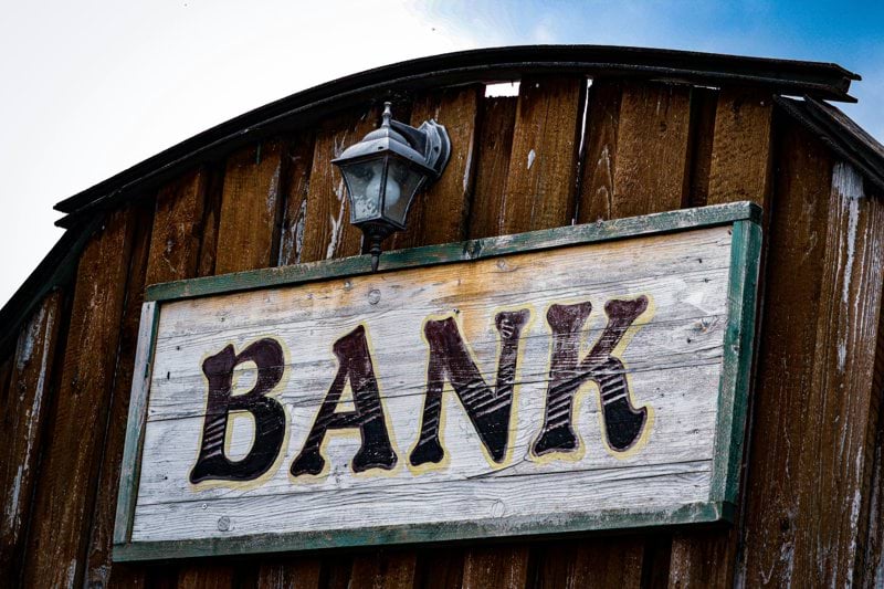 a bank sign on the side of a wooden building