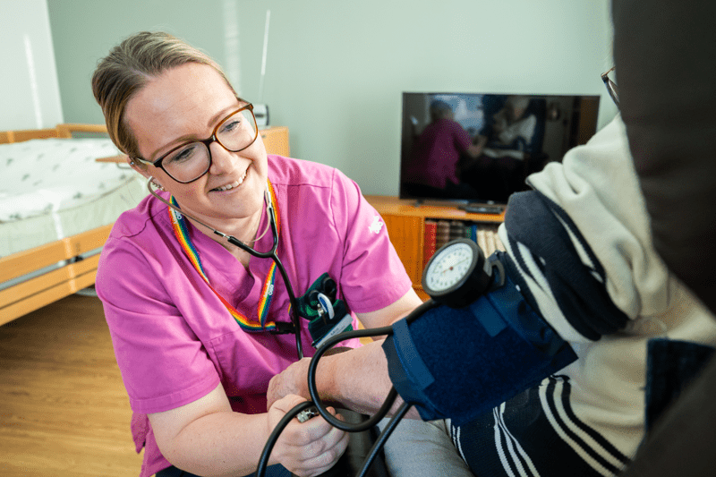 Medarbetare tar blodtryck på en patient